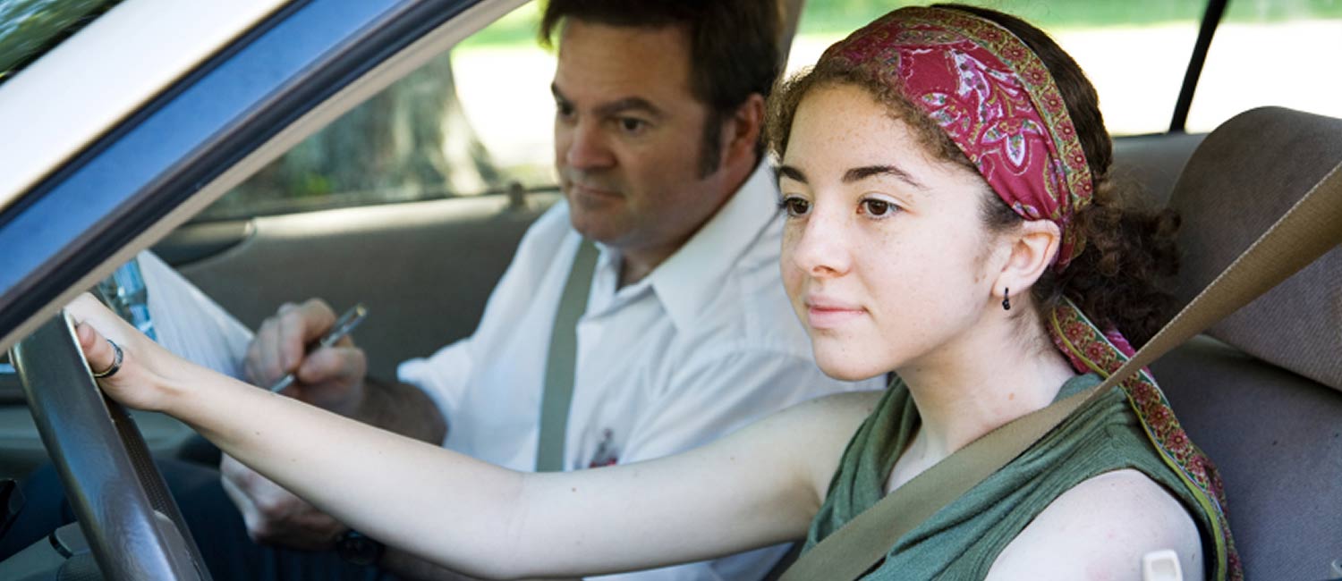 A woman being taught how to drive in a Derek Brown's Academy of Driving car.