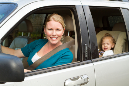 A woman driving with a baby in a car seat